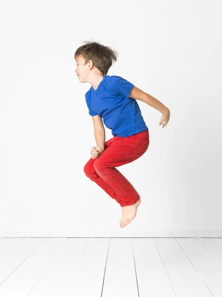 Cute Boy Blue Shirt Red Trousers Jumping High Wooden Floor — Stock Photo, Image