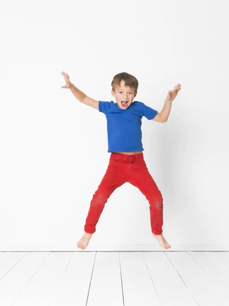 Schattige Jongen Blauw Shirt Rode Broek Hoog Springen Houten Vloer — Stockfoto