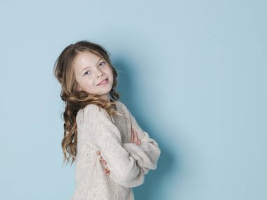 mavi arka plan önünde poz yün kazak giyen güzel ve serin kız 