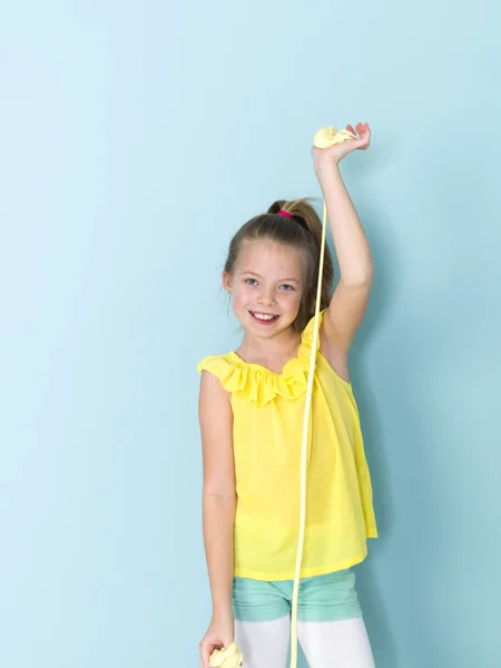 Schönes Kleines Mädchen Das Mit Gelbem Schleim Vor Blauem Hintergrund — Stockfoto