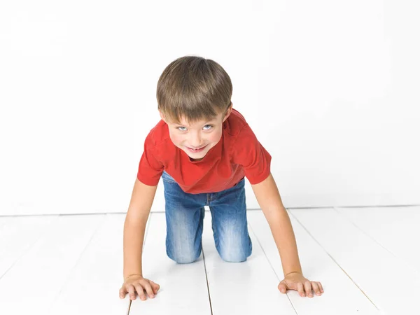 Cute Blond Boy Red Shirt Blue Jeans Posing White Wooden — Stock Photo, Image
