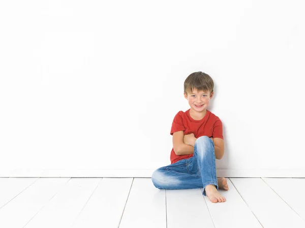 Cute Blond Boy Red Shirt Blue Jeans Sitting Crossed Arms — Stock Photo, Image