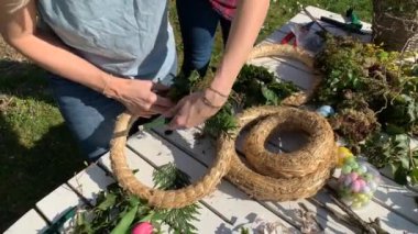kadın çiçekçiler bahçede ahşap masa üzerinde el yapımı çiçek çelenk yapma 
