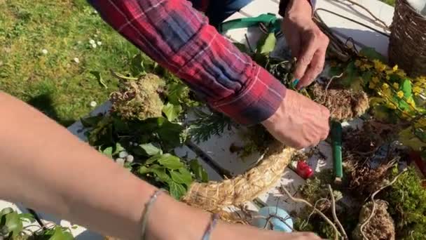 Vrouwelijke Bloemisten Maken Handgemaakte Bloemen Krans Houten Tafel Tuin — Stockvideo