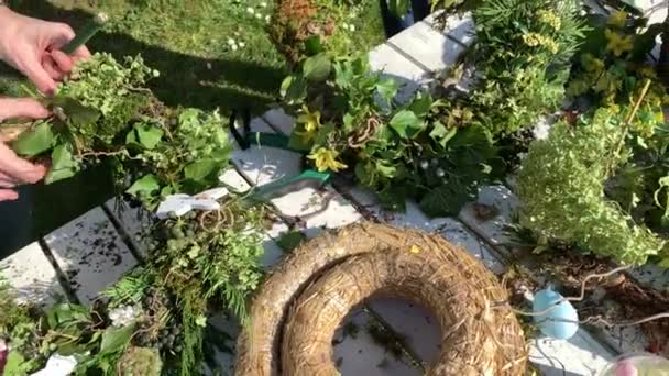 fleuristes féminines faisant des couronnes florales faites à la main sur une table en bois dans le jardin  