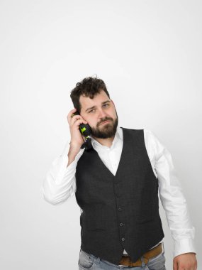 siyah sakallı yakışıklı adam kulaklık müzik dinlerken ve beyaz stüdyo duvar önünde poz