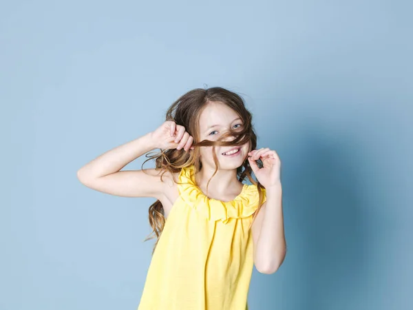 Χαμογελαστή Όμορφη Μελαχρινή Κορίτσι Στην Κίτρινη Κορυφή Παίζοντας Μαλλιά Ενώ — Φωτογραφία Αρχείου