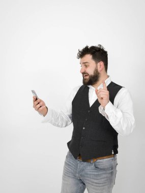 siyah sakallı adam akıllı telefon ekranına bakıyor ve beyaz arka plan önünde fikir işareti gösteren