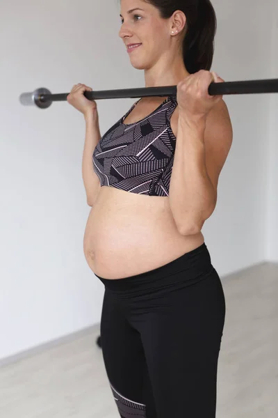 Schöne Junge Schwangere Frau Schwarzer Sportbekleidung Beim Fitnesstraining Mit Langhantelstange — Stockfoto