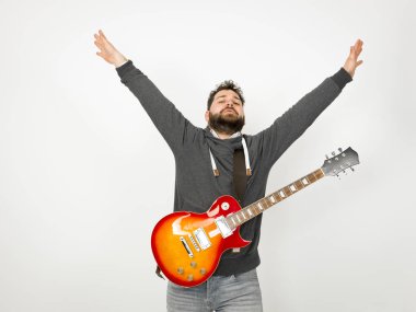 cool man with black hair and beard wearing grey hoodie playing electric guitar in front of white background