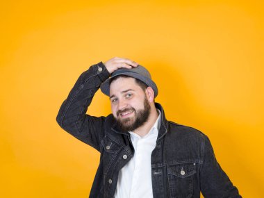 turuncu arka planda poz şapka ile serin sakallı adam