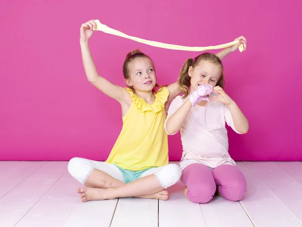 Irmãs Divertindo Enquanto Brincava Com Slimes Caseiros Frente Fundo Rosa — Fotografia de Stock