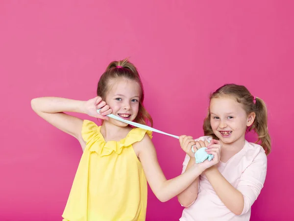 Irmãs Divertindo Enquanto Brincava Com Slimes Caseiros Frente Fundo Rosa — Fotografia de Stock