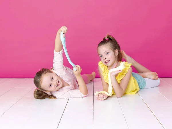 Irmãs Divertindo Enquanto Brincava Com Slimes Caseiros Frente Fundo Rosa — Fotografia de Stock