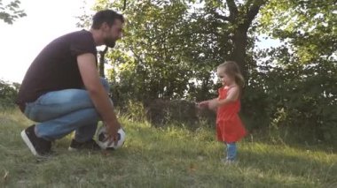 Baba ve kızı yaz günü Glade 'de futbol topuyla oynuyorlar.  