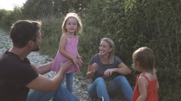 Güneşli Bir Günde Çayırların Arasında Yürüyüş Yapan Iki Çocuklu Ebeveynler — Stok video