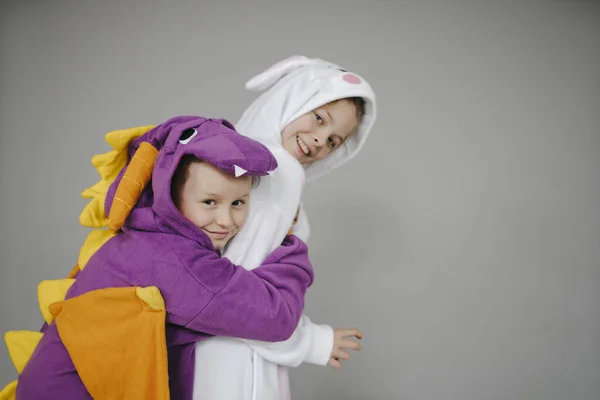 two girls dressed as rabbit and dragon posing in front of grey background
