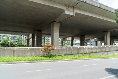 Şehirdeki üst geçidin altında beton yapı ve asfalt yol alanı