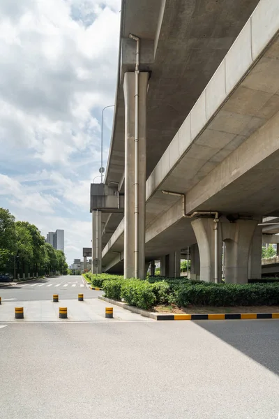 Şehirdeki üst geçidin altında beton yapı ve asfalt yol alanı