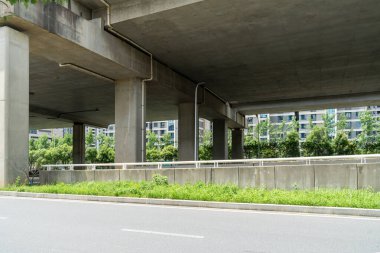 Şehirdeki üst geçidin altında beton yapı ve asfalt yol alanı