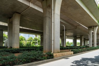 Şehirdeki üst geçidin altında beton yapı ve asfalt yol alanı