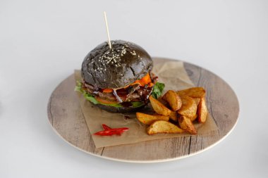 Burger patates dilimleri bir ahşap tepsi ile