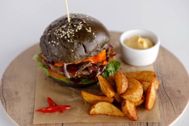 Burger patates dilimleri bir ahşap tepsi ile