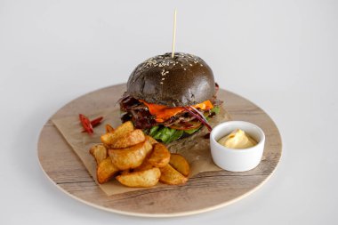 Burger patates dilimleri bir ahşap tepsi ile