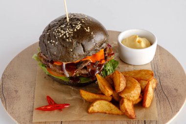 Burger patates dilimleri bir ahşap tepsi ile