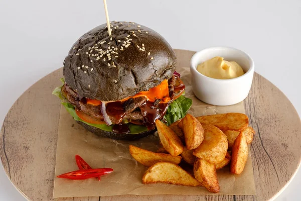 Burger patates dilimleri bir ahşap tepsi ile