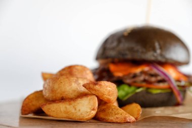 Burger patates dilimleri bir ahşap tepsi ile