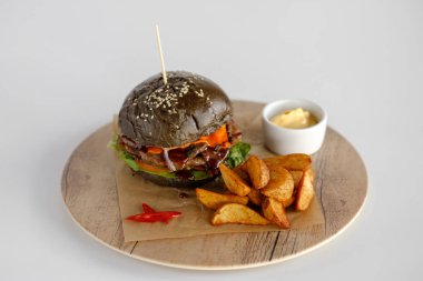 Burger patates dilimleri bir ahşap tepsi ile