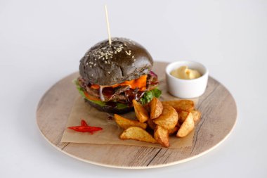 Burger patates dilimleri bir ahşap tepsi ile