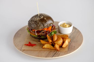 Burger patates dilimleri bir ahşap tepsi ile