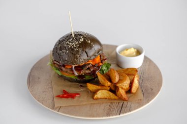 Burger patates dilimleri bir ahşap tepsi ile