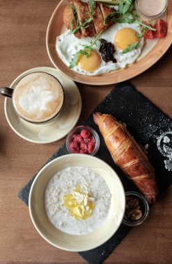 Kahvaltı iki kümesi. Çilek ile yulaf lapası, kızarmış yumurta tavuk