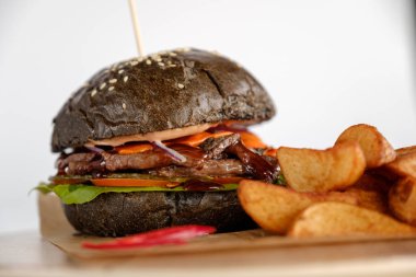 Burger patates dilimleri bir ahşap tepsi ile