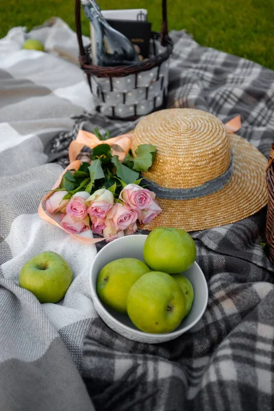 Picnic. Sombrero de paja, manzana y flores en el césped — Foto de Stock