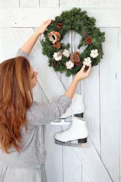 Genç kadın bir Noel çelenk kapıda asılı