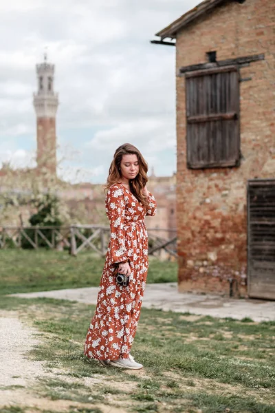 Una hermosa chica en un vestido largo caminando por la antigua ciudad de Siena — Foto de Stock