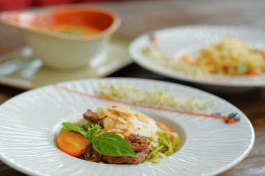 Beyaz bir tabak içinde fesleğen ve mozzarella peynirli spagetti