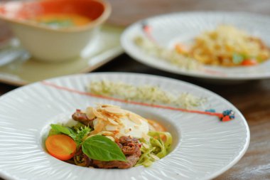 Beyaz bir tabak içinde fesleğen ve mozzarella peynirli spagetti