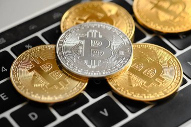Bitcoins ve Yeni Sanal para kavramı. Dizüstü bilgisayarın klavyesinde B simgesi olan altın sikkeler