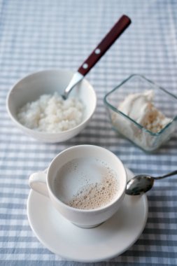 Sütlü beyaz fincan kahve, masada şeker