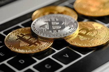 Bitcoins ve Yeni Sanal para kavramı. Dizüstü bilgisayarın klavyesinde B simgesi olan altın sikkeler