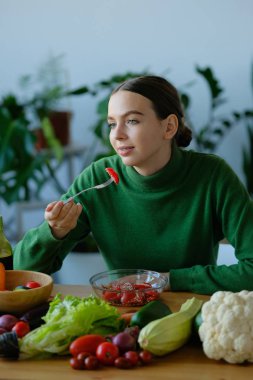 genç vegan kadın ev iç mutfakta salata yeme
