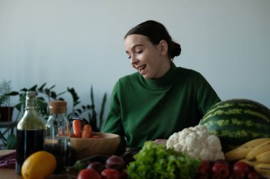 genç vegan kadın ev iç sebzeler ile mutfak masasında telefon kullanarak