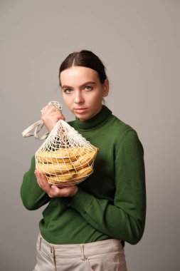 genç kadın ev iç muz ile dize çanta tutan