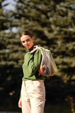 sokak dış bakkaliye ile dize çanta tutan genç kadın