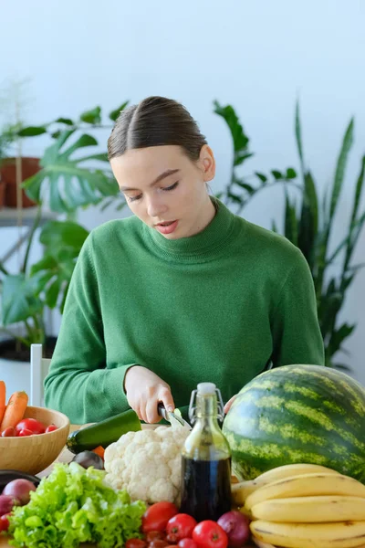 家庭のインテリアで野菜を切る若い女性 — ストック写真
